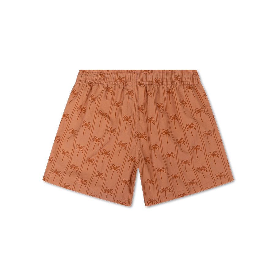 The back of brown swim shorts with palm tree pattern on a white background