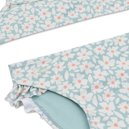 Close-up of a floral-patterned bikini with white flowers and pink centers on a white background