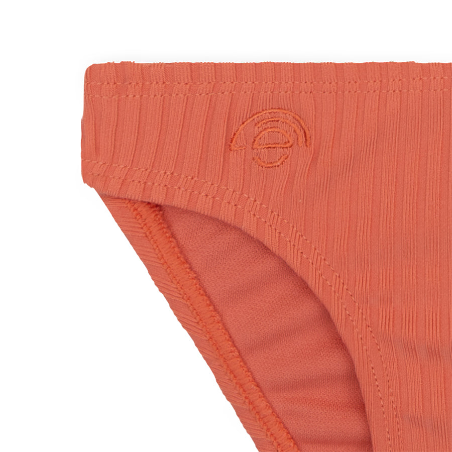 Close-up of an orange bikini bottom with a brand logo on a white background