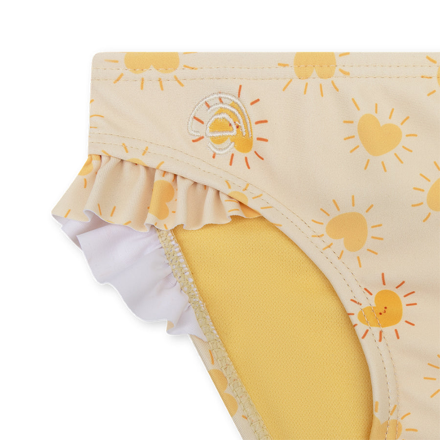 Yellow bikini bottoms with ruffles with sun pattern on a white background