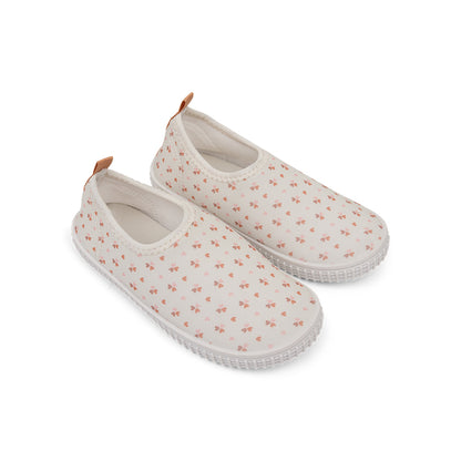 Pair of old pink water shoes with small cozy hearts pattern on a white background