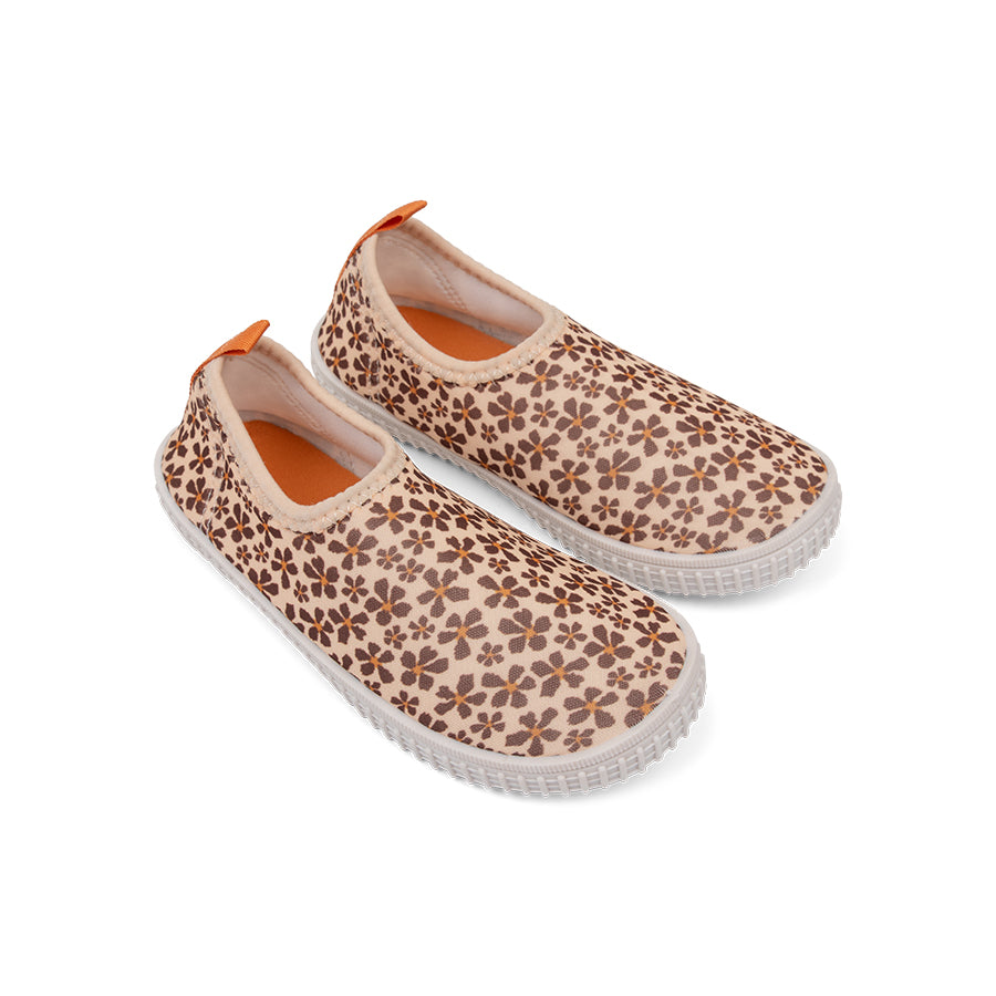 Pair of wild flower-patterned shoes with orange sole on a white background