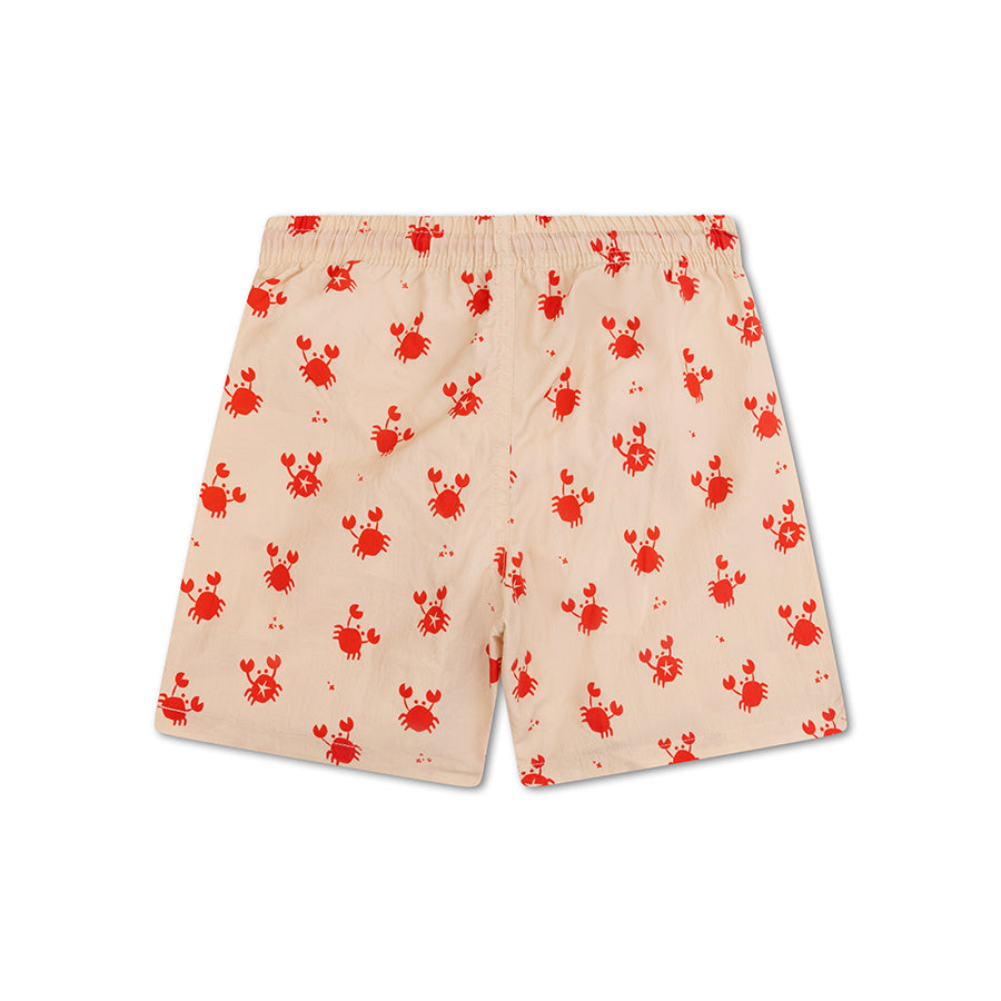 The back of beige swim shorts with red crab pattern on a white background