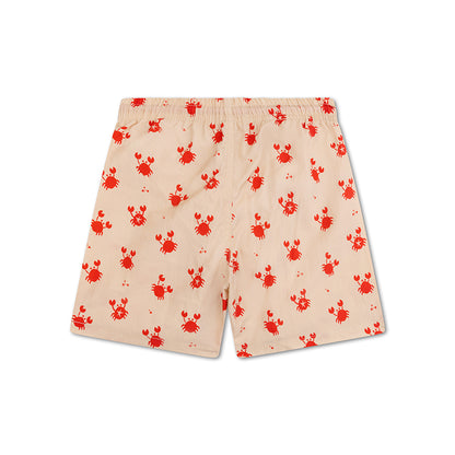 The back of beige swim shorts with red crab pattern on a white background