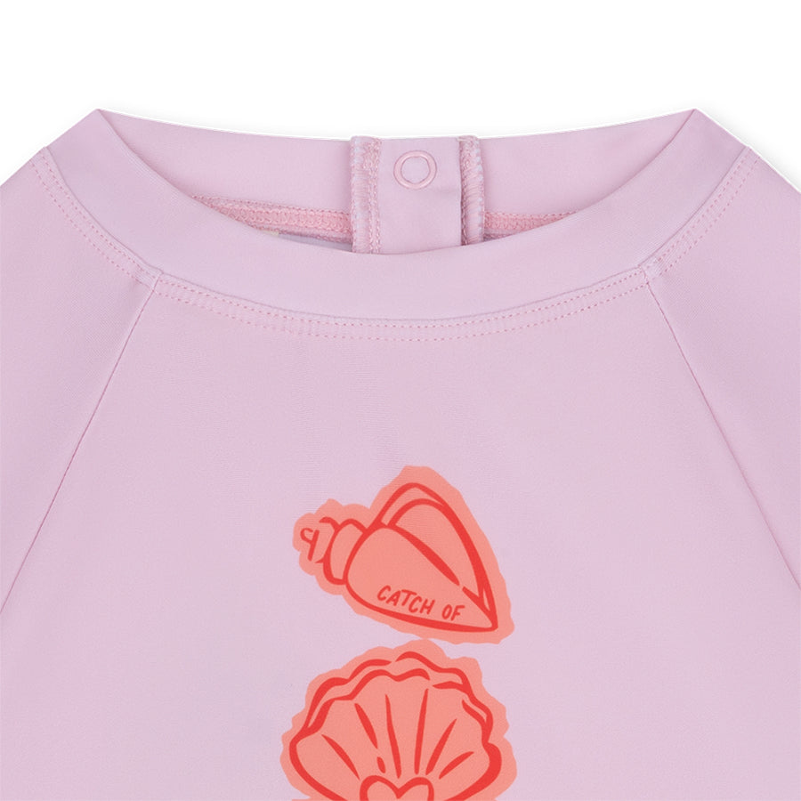 Pink shirt with shell designs and Coastal Charm on a white background