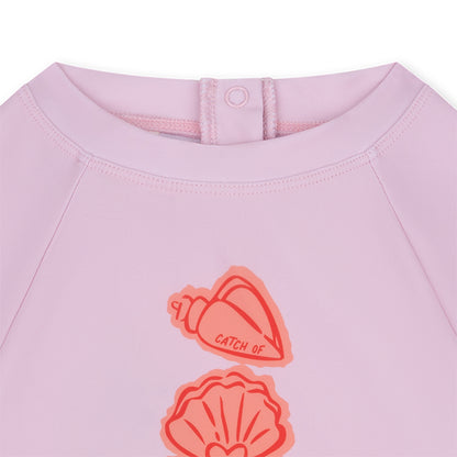 Pink shirt with shell designs and Coastal Charm on a white background