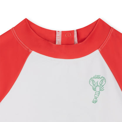 Close-up of a red and white shirt with a green lobster logo on a white background