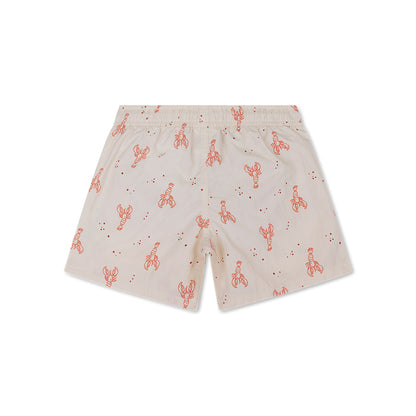 The back of beige swim shorts with red lobster pattern on a white background