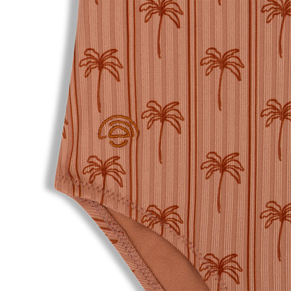 Close-up of a swimsuit with palm tree pattern on a white background