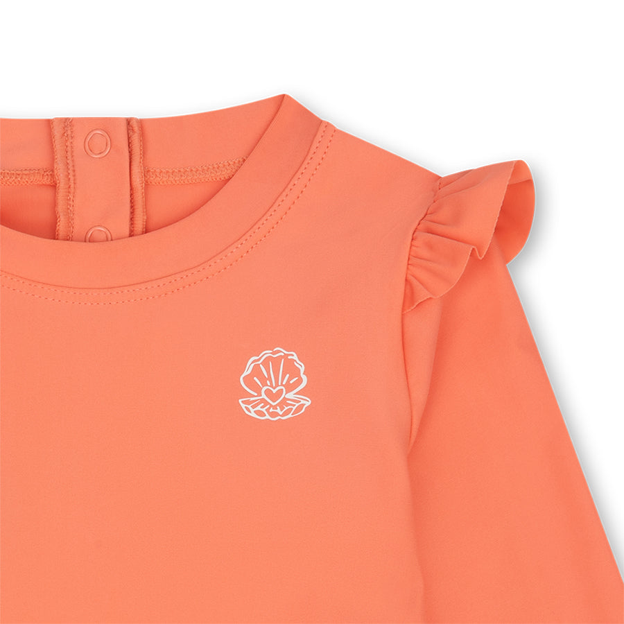 Pink shirt with a white shell logo on a white background